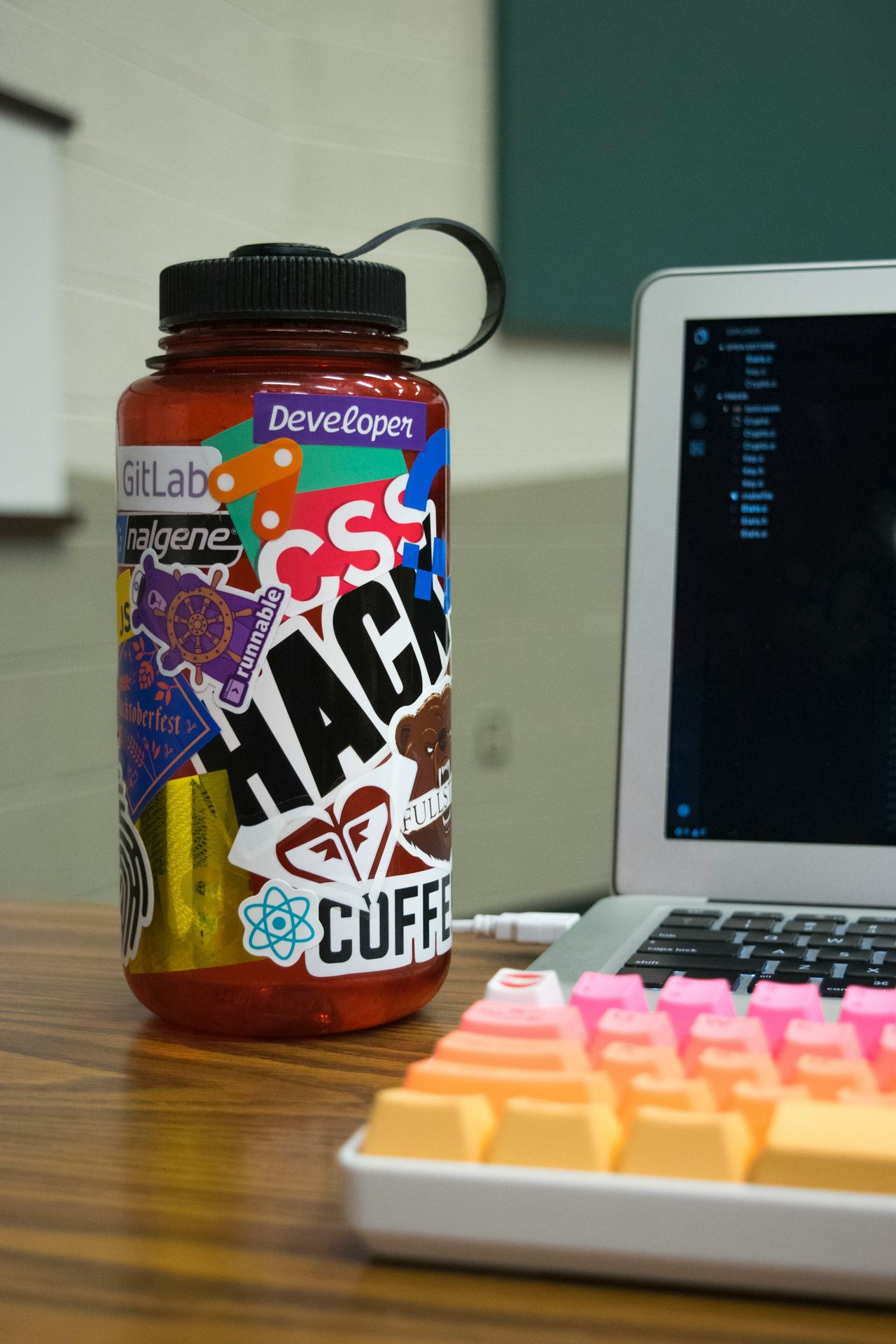 multicolored plastic bottle beside laptop